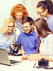 Image showing smiling team with laptop and photocamera in office