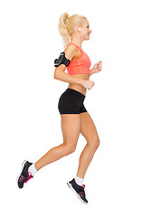 Image showing sporty woman running with smartphone and earphones