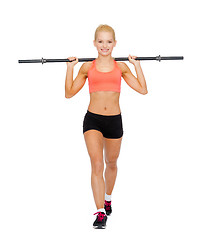 Image showing smiling sporty woman exercising with barbell