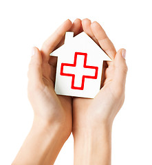 Image showing hands holding paper house with red cross