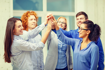 Image showing creative team doing high five gesture in office