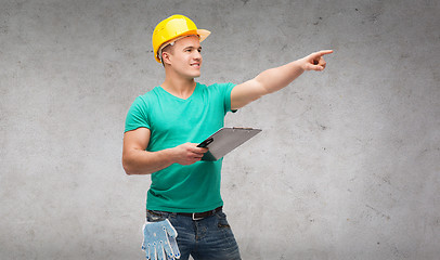 Image showing smiling man in helmet with clipboard