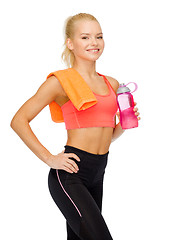 Image showing smiling sporty woman with water bottle and towel