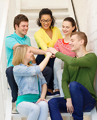 Image showing smiling students with hands on top of each other