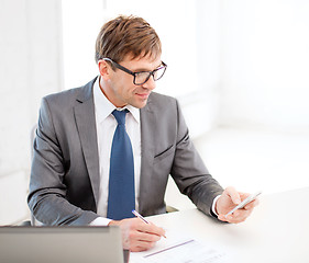 Image showing businessman working with laptop and smartphone