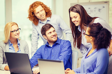 Image showing smiling team with laptop computers in office