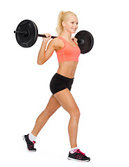 Image showing smiling sporty woman exercising with barbell