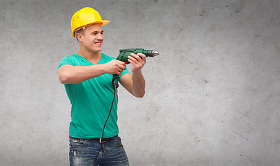 Image showing smiling manual worker in helmet with drill machine