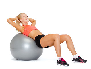 Image showing smiling sporty woman exercising on fitness ball