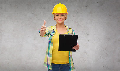 Image showing smiling woman in helmet with clipboard