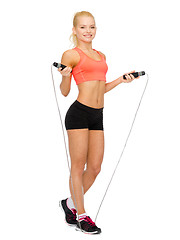 Image showing smiling sporty woman with with skipping rope