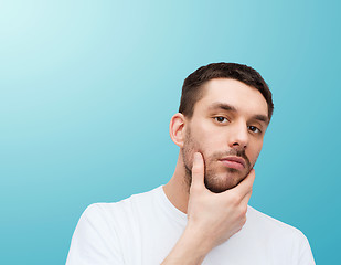 Image showing beautiful calm man touching his face