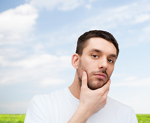 Image showing beautiful calm man touching his face