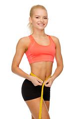 Image showing smiling sporty woman with measuring tape