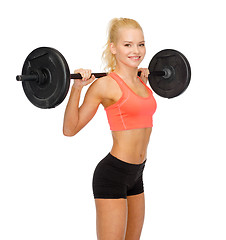 Image showing smiling sporty woman exercising with barbell