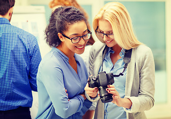 Image showing two women looking at digital camera at office