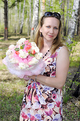 Image showing the happy woman with a bouquet from soft toys costs in the wood.