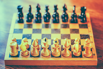 Image showing Ancient wooden chess standing on chessboard