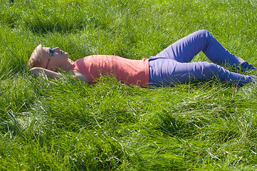 Image showing Young trendy man lying on the grass