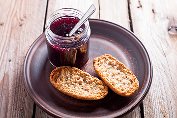 Image showing black currant jam in glass jar and crackers