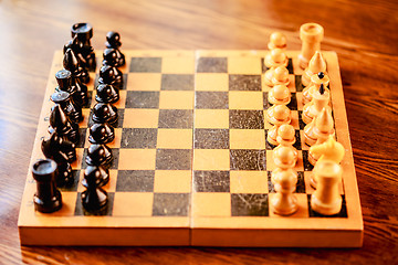 Image showing Ancient wooden chess standing on chessboard