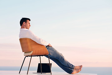 Image showing relaxed young man at home on balcony