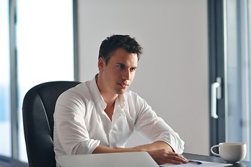 Image showing frustrated young business man working on laptop computer at home