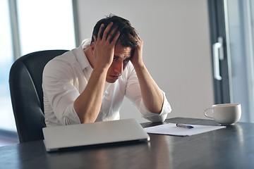 Image showing frustrated young business man working on laptop computer at home