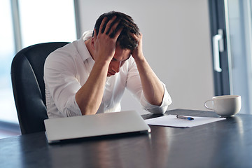 Image showing frustrated young business man working on laptop computer at home