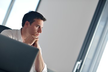 Image showing business man working on laptop computer at home