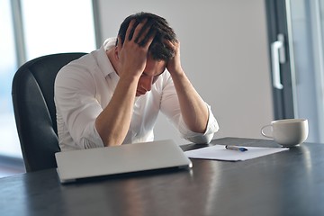 Image showing frustrated young business man working on laptop computer at home