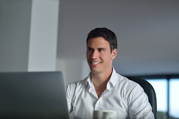 Image showing business man working on laptop computer at home