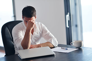 Image showing frustrated young business man working on laptop computer at home