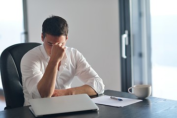 Image showing frustrated young business man working on laptop computer at home