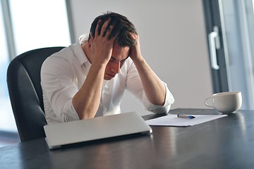 Image showing frustrated young business man working on laptop computer at home