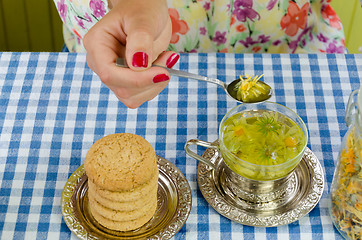 Image showing cup dried marigold tea hand hold spoon with flower