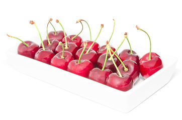 Image showing White square dish arranged with big ripe cherry berries