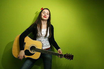 Image showing Brunette posing with guitar