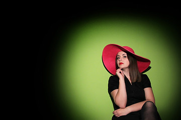 Image showing Young woman with pink hat posing on bed