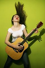 Image showing Young woman passionately playing guitar