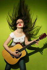 Image showing Young woman wildly playing guitar