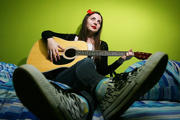 Image showing Brunette playing guitar