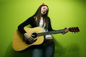 Image showing Woman  enjoys playing guitar
