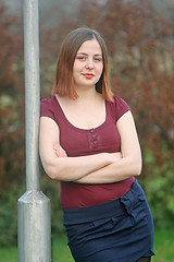 Image showing Woman leaning against street pole