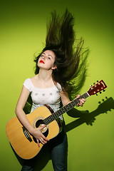 Image showing Young brunette playing guitar