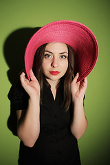 Image showing Girl with pink hat on green background