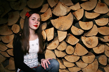Image showing Young woman posing with chopped wood