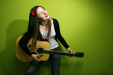 Image showing Brunette enjoys playing guitar