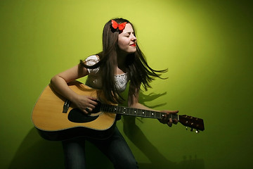 Image showing Young woman enjoys playing guitar