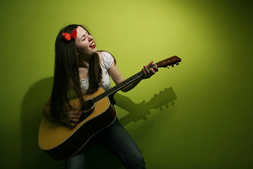 Image showing Brunette wildly playing guitar